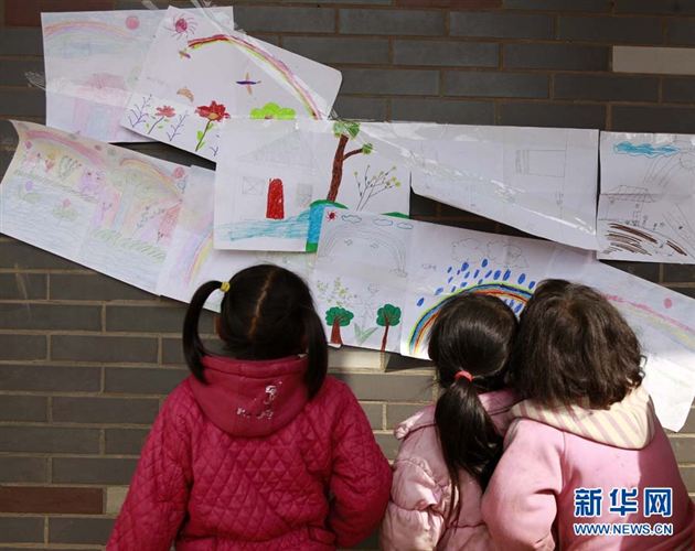 苗寨小学的几个女孩子在两所学校的“美术联展”上欣赏画作