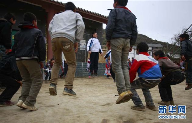 一名棠外的学生带领苗寨小学的一帮男孩子们课间游戏