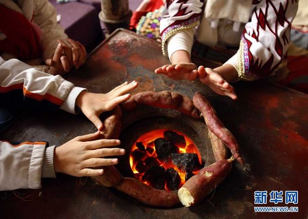 放学后，爱心互助小组的学生们聚到苗寨小学一名学生家里，在炉边烤红薯